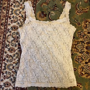 Cremevit Spetslinne från hanky panky  - Det står storlek S, men den har stretchats ut väldigt mycket. Därför skulle jag säga M eller till och med L. Mest troligen M. Svarta noppor finns här och var. 35 cm bred när den mäts platt, men den är väldigt stretchig.