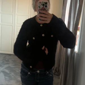 Svart teddyjacka med silvriga knappar - Mysig svart kofta från hm, den har silvriga knappar vilket skapar en elegant men mysig look, den är ganska tjock i materialet, använd 1 gång men köpt för något år sedan, nypris 499