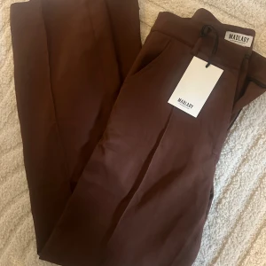 Bruna mjukisbyxor från Madlady - Säljer ett par bruna kostymbyxor från Madlady. Byxorna har en avslappnad passform. Helt oanvända. 