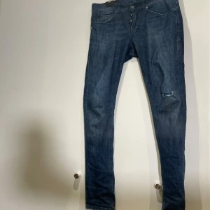 Dondup - Snygga blå jeans från Dondup i skinny fit-modell. Klassisk femficksdesign med smal passform och slitning på ena benet för en cool look. Perfekta för dig som gillar tajta jeans med lite edge.
