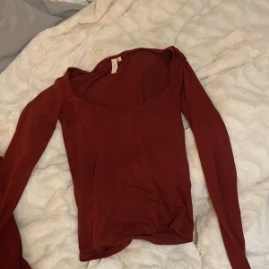 Vinröd långärmad topp från Nelly - Snygg vinröd långärmad topp från Nelly i storlek XS. Modellen har en djup, rundad halsringning med en liten spetskant som detalj. Tunn och mjuk. Den är mer vinröd i verkligheten❤️