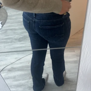 Low waist bootcut jeans - Snygga mörkblå jeans från 7 For All Mankind med bootcut. Storlek 24 säljer för de är för små, jättefint skick. Superfina detaljer på fickorna som gör de unika!💕