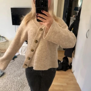 Beige stickad tröja med knappar - Säljer denna stickade tröja med sned sydda knappar, storlek S men passar även M !!