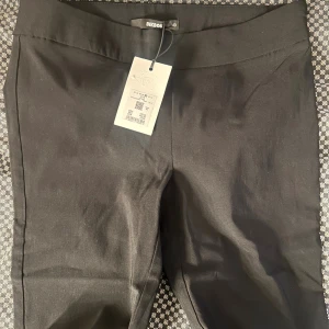 Svarta kostymbyxor från Bik Bok - Svarta kostymbyxor från Bik Bok i klassisk rak modell. Byxorna har en hög midja och är sydda i ett slätt tyg som ger en stilren look. Perfekta att matcha med en snygg topp eller skjorta för en clean vibe.