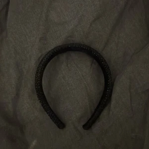 Svart glittrigt diadem - Snyggt svart diadem med glittriga stenar som ger en lyxig känsla. Bred modell som sitter bekvämt på huvudet och passar perfekt när du vill addera lite extra bling till din look. Perfekt accessoar för att lyfta vilken outfit som helst.