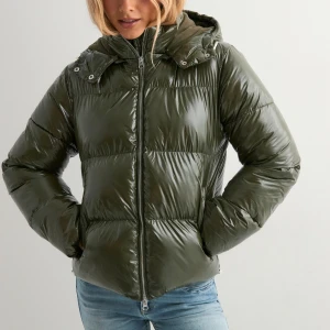 Mörkgrön pufferjacka med huva - Säljer nu min jacka från nelly då jag tycker att färgen inte passade mig, jackan är helt oanvänd, köpt för ca 1-2 månader sedan men jag kan inte skicka tillbaks den då den utgått ur nelly sortiment, därav gör jag ett försök att sälja den här