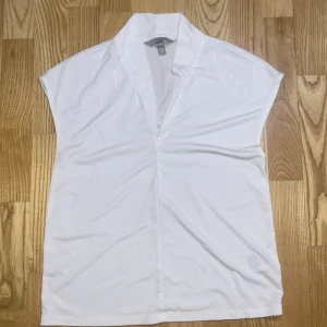 Vit omlott blus från H&M XS - Säljer en vit blus från H&M i storlek XS. Blusen har en omlott-look med v-ringad krage och är ärmlös. Materialet är mjukt och lätt, perfekt för en clean och fräsch stil. Passar dig som gillar minimalistiska plagg med snygg passform.