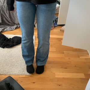 Blå bootcut jeans  - Säljer ett par blå jeans. Jeansen har klassiska fickor både fram och bak och är tillverkade i ett mjukt denimtyg. 
