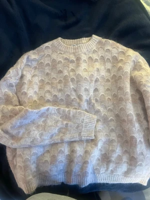 Beige stickad tröja från Zara - Mysig beige stickad tröja från Zara med rund halsringning och ett unikt mönster i ljusa toner. 