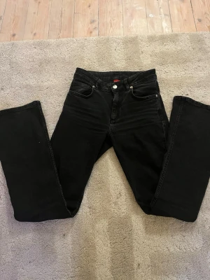 Svarta bootcut jeans mid-waist RYVLS - Säljer ett par svarta bootcut jeans från ryvls. Jeansen har inga defekter och har använts 2-3 gånger. St 164