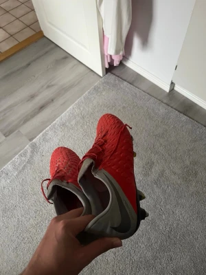 Nike röda fotbollsskor med dobbar - Säljer ett par gamla Nike skor då de ej används längre. KOLLA ALLA BILDER. Priset går att förhandla om de går snabbt då jag vill bli av med dem.
