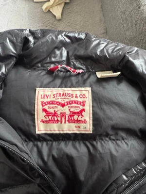 Levisjacka  - Glansig levisjacka! Använd en del så finns små skavanker men ingenting som stör helhetsintrycket! Storlek XS