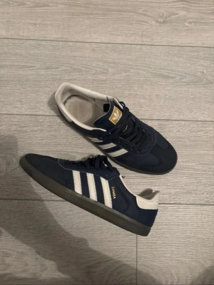 Adidas Samba navy - Säljer ett par klassiska Adidas Samba sneakers i riktigt fet mörkblå färg. Dem är väldigt bra skick och har endast en liten fläck som enkelt går att få bort.