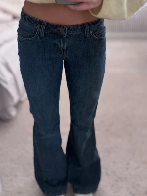 Mörkblå Weekday jeans  - Säljer ett par snygga mörkblå jeans i lågmidjad modell med utsvängda ben från Weekday. Klassisk denim som passar till allt och sitter jättefint. Storlek 25/32💕