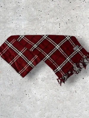 Burberry halsduk - Säljer en snygg vinröd Burberry halsduk med det ikoniska rutmönstret. Tillverkad i 100% mjuk och värmande ull.  📏 Mått: Längd-140cm, Bredd-30cm Pris kan diskuteras!