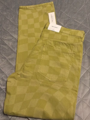 Gula rutiga jeans från Vaillant i str XL - Snygga gula jeans från Vaillant med schackrutigt mönster i ton-i-ton. Modellen har raka ben och klassisk femficksdesign. Perfekta för dig som vill sticka ut med en cool och trendig look. Materialet är mjukt och bekvämt, passar perfekt till streetwear-stilen.