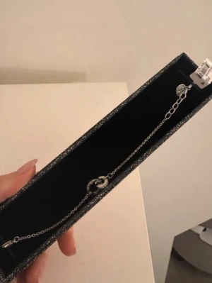 Silverfärgat armband från Edblad - Snyggt och stilrent armband från Edblad i silverfärg. Armbandet har en tunn kedja och ett dekorativt cirkelformat hänge i mitten. Perfekt för dig som gillar minimalistiska smycken och vill ha något som passar till många olika looks.