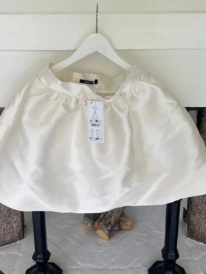 Vit kortkjol från Gina Tricot - Säljer en vit kortkjol från Gina Tricot med enkel och stilren design. Kjolen har en lätt utställd form och resår i midjan för skön passform. Perfekt att matcha med en crop top eller oversized tröja.