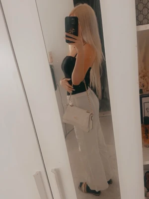 Vita byxor  - Säljer ett par snygga vita chinos från HM med normal passform och raka, vida ben. Byxorna har fickor fram och bak samt klassisk midja. Perfekta för en trendig och avslappnad look.