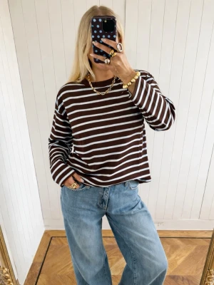  randig långärmad topp - Säljer en brun och randig långärmad topp med avslappnad passform, i mycket fint skick🤎