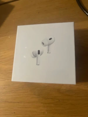 AirPods Pro (2nd generation) MagSafe USB-C - Nya AirPods Pro (2nd generation) med MagSafe-laddningsetui och USB-C. Oöppnad förpackning, senaste modellen med aktiv brusreducering, transparensläge och förbättrad batteritid. Perfekt för både musik och samtal. Inga synliga defekter eller slitage.