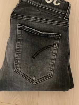 Dondup jeans, 30 - Snygga grå jeans från Dondup, tillverkade i Italien. Jeansen har klassisk femficksdesign, diskreta slitningar och en metall-logga vid bakfickan. Materialet är robust denim som ger en cool vibe.