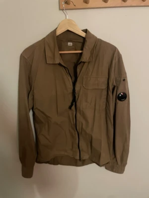 Brun overshirt från C.P. Company - Säljer en brun overshirt från C.P. Company I storlek S. Jackan är hyfsat använd och har inge noterbara defekter. Passar dig som är drygt  170-180 cm lång.