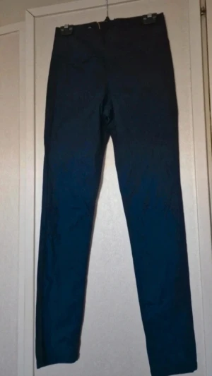 Marinblå skinny byxor med dragkedja - Endast använda ett fåtal gånger. Det är några mindre fläckar (se bilder). Byxorna är endast ångade inför försäljning så mycket möjligt att de försvinner i tvätten med fläckborttagning. Stl S/M