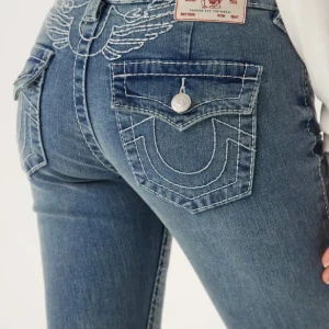 Söker!! True Religion blå bootcut jeans - Söker dessa jeans från True Religion med ikoniska kontrastsömmar o vingar där bak. Gärna nästan som nytt skick. Men funkar om dom är bra använt skick utan defekter i strl 25 Hör av dig om du har o säljer.❤️