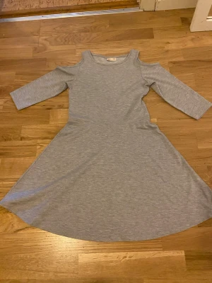Grå offshoulder klänning från Kappahl  - Snygg grå klänning från Kappahl med offshoulder-detalj och trekvartsärm. Strl 146 och passar perfekt nu till nyår!!