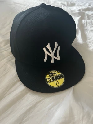 Svart New Era 59FIFTY NY Yankees keps - Säljer en svart New Era 59FIFTY keps med klassisk NY Yankees-logga. Den är helt ny och oanvänd, säljer då den var för liten i storlek för mig. 