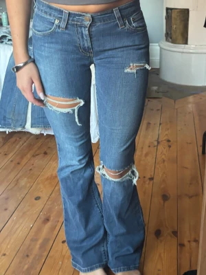 Levis blå bootcut jeans med slitningar - Jeans med hål från Levis, osäker på storlek men skulle säga 34