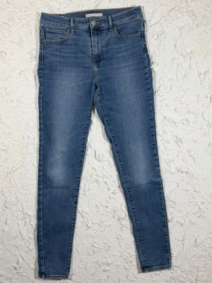 Levi's 720 High Rise Super Skinny jeans - Säljer ett par Levi's 720 High Rise Super Skinny jeans i klassisk blå tvätt. De har hög midja, smal passform hela vägen ner och fem fickor. Jeansen är gjorda i stretchigt denim för extra komfort och har Levi's ikoniska bakfickor med logga.