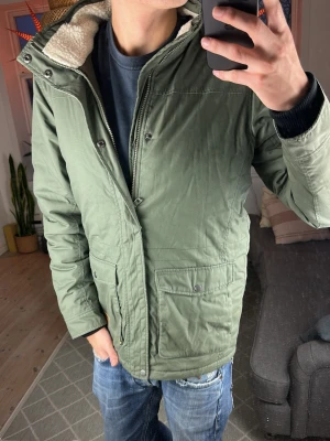 Pälsfodrad jacka olivgrön  - Skön jacka med pälsfodrad krage. Mycket bra skick, skriv vid fundering! Mått: A:58 B:48 C:48 D:73 (cm) 😇🙏