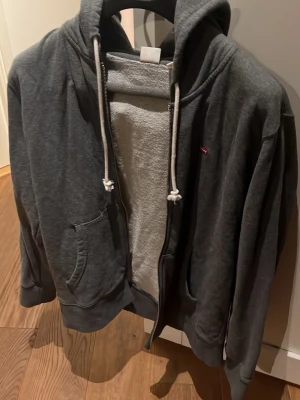 Grå Levis zip hoodie - Grå Levis zip hoodie som aldrig används med ett riktigt varmt och tjockt material.