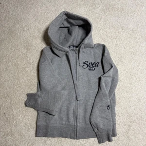 Grå ziphoodie från Svea strl XS - Mjuk och skön hoodie med dragkedja i strl XS från märket Svea 