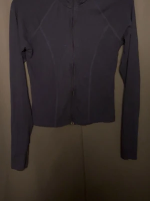 Mörkblå zip kofta från Gina Tricot - Mörkblå kofta från Gina Tricot i storlek L sitter som M Tröjan har lång ärm, figurnära passform och hel dragkedja framtill. Perfekt till lager på lager och enkel att matcha med olika outfits.