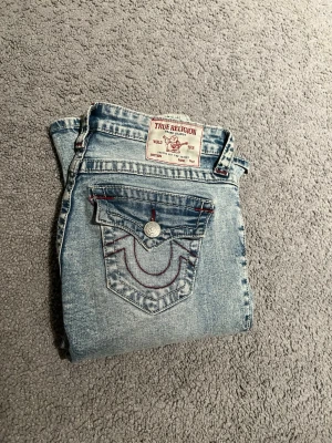 True Religion ljusblå bootcut jeans - Säljer mina true religion jeans i storlek 24😊 säljer dem då de inte kommer till användning.  En knapp saknas på framsidan men är inget synligt se bild ovan. Pris kan diskuteras ❤️hör av dig vid frågor och intresse 