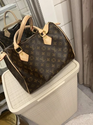 Brun handväska  - Brun handväska med monogrammönster. Väl använd & skickat till syerska som både sytt & limmat på vissa ställen osv. För fler bilder skicka meddelande. Mycket fin & gammal väska därav det billiga priset 🤍 • Instagram: Ginise > Tiktok: Ginise • 