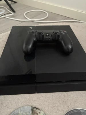 PlayStation 4 med handkontroll och spel - Sony PlayStation 4 i gott skick med en original handkontroll. Flera populära spel, bl.a. The Last of Us Remastered, Star Wars Jedi: Fallen Order, GTA V, Crash Bandicoot och FIFA. Perfekt för spelkvällar! Mindre ytslitage kan förekomma. Alla spel kommer inte med du för välja vilka som du vill få med 
