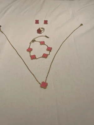 Fyrklöver ros set - Bilderna visar det av 18k guldpläterade smycken med rosa stenar. Set av halsband, armband, örhängen och ring. 