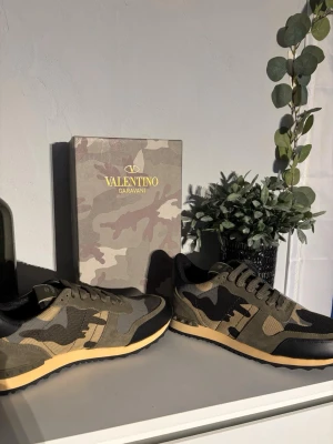 Valentino Garavani Rockrunner sneakers - Snygga Valentino Garavani Rockrunner sneakers i camouflage med olivgröna, svarta och beige toner. Skorna har detaljer i mocka, mesh och skinn samt en cool nubbad sula. Perfekta för dig som vill sticka ut med exklusiva och trendiga sneakers.