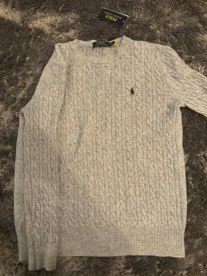 Grå tröja Polo Ralph Lauren - Grå tröja från Polo Ralph Lauren i storlek S. Perfekt för höst och vinter eller om du vill vara fin klädd till ett speciellt tillfälle! Vid frågor och funderingar skicka iväg ett meddelande! 