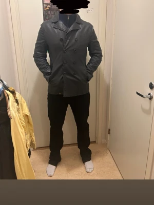 Tiger of sweden jacka - Tiger of Sweden – exklusiv herrjacka Jacka i skinnliknande Limonta-tyg (made in Italy). Klassisk dubbelknäppt modell med hög kvalitet och snygg passform. Lätt, slitstark och perfekt för vår/höst. Nypris uppskattningsvis ca 3 000–5 000 kr. • Storlek: L • Färg: Svart • Material: Limonta technical fabric. Pris kan diskuteras!! Tveka inte att skriva!!