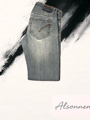 Dondup george ljusblå skinny jeans - Dondup george jeans i ljusblå tvätt med slitningar och trasiga detaljer vid knäna. Skinny fit med klassiska fem fickor och snygga broderade detaljer på bakfickorna. Tillverkade i Italien av mjukt jeanstyg med stretch för skön passform. Har även en defekt vid knät, kan gå bort i tvätten med lite medel.