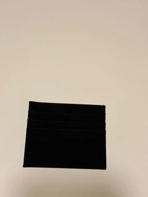 Plånbok i mocka - Mocka plånbok med fack för kort. Tillverkat i mjuk mocka som ger en stilren och lyxig känsla. Perfekt storlek för fickan och enkel att ta med överallt. Helt ny och stilren.