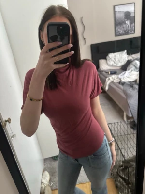 Mörkrosa t-shirt från 157 - Säljer en enkel och snygg mörkrosa t-shirt från 157. Modellen är kortärmad med en klassisk rund halsringning och normal passform. Perfekt till jeans eller shorts för en chill look.