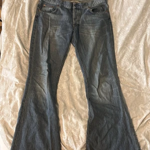 lågmidjade jeans - säljer dessa low/mid rise flare jeans som köptes på plick för ett tag sedan. gjort hål för att lägga till ett skosnöre då de är för stora i midjan för mig, går att få med om man vill. jeansen är slitna längst ner på benen💘