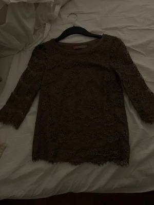 Brun spetsblus från Saint Tropez - Säljer en brun blus från Saint Tropez i storlek XS men passar mig som vanligt har S. Blusen har långa ärmar och är helt täckt av vacker spets med blommigt mönster. Perfekt för dig som gillar romantiska detaljer och en feminin look.