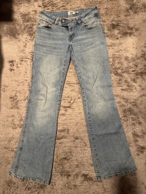 Bootcut jeans från 157 i ljusblå denim - Säljer ett par ljusblå bootcut jeans från 157 med snygg broderad detalj i guld på bakfickorna!💕 Använt de i 1 gång och bestämde att sälja. Klassisk femficksmodell med dubbla knappar i midjan och bälteshällor. Perfekta för dig som gillar retrovibbar och vill ha ett par jeans med lite extra attityd.